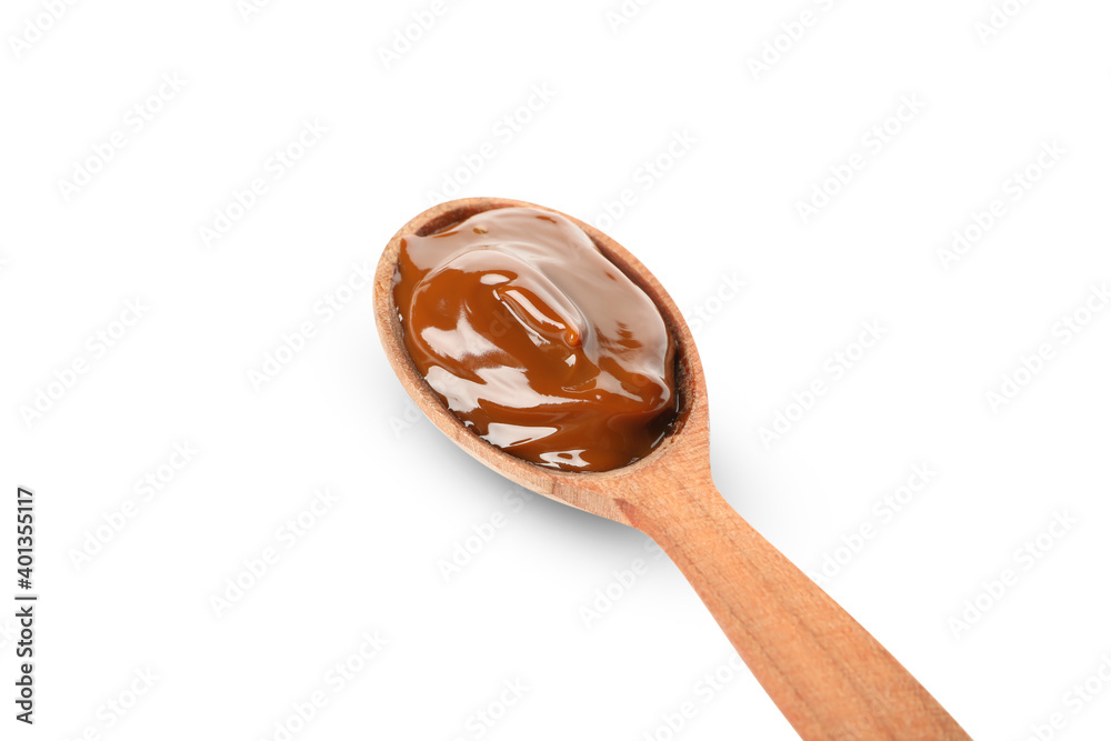 Spoon with caramel condensed milk isolated on white background
