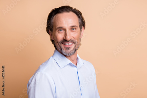Close-up portrait of nice cheerful content middle aged man copy space isolated over beige pastel color background