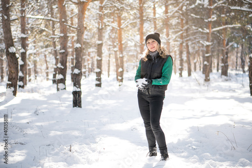 Woman plays snowballs in winter forest. Camping concept.