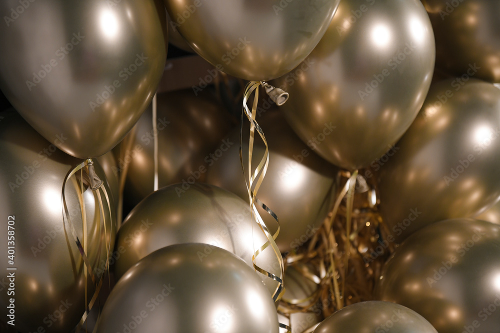 Celebration and party golden christmas baloons with golden ribbons isolated on black background. Event decoration. New year eve. Christmas party.