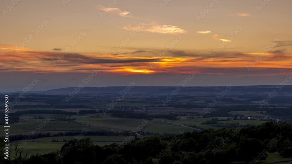 Wide Timelapse of sunset and Beskydy countryside landscape with orange clouds and setting sun overlooking the main road during bussy road traffic. Wide Timelapse of sunset and Beskydy countryside landscape with orange clouds and setting sun overlooking the main road during bussy road traffic.