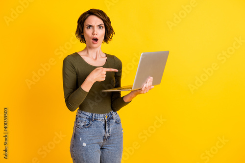 Photo of astonished lady point index finger laptop shout wear jumper isolated over bright yellow color background