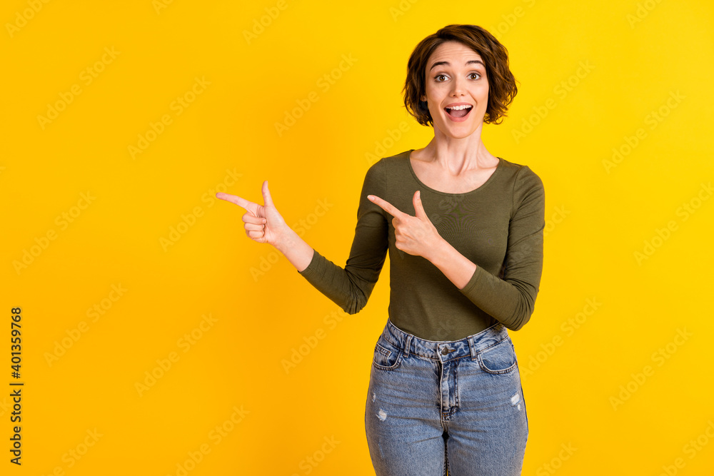 Photo of shocked lady point index finger empty space for ads promotion isolated over bright yellow color background Photo of shocked lady point index finger empty space for ads promotion isolated over bright yellow color background