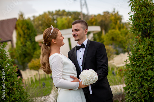 Bride and groom smiling outdoor, groom holding bride. Wedding couple in love
