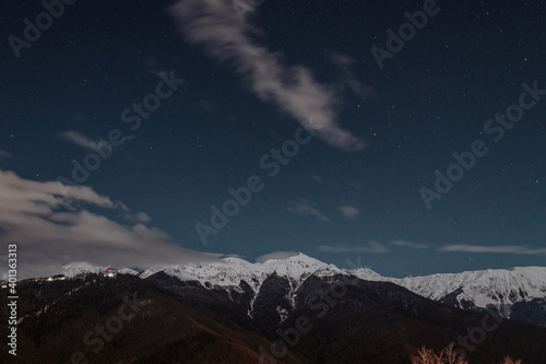 Long exposure photograph of the mountains at night. There are many stars in the sky