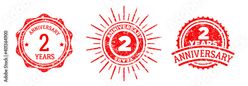 A group of 2 years anniversary logos drawn in the form of stamps, red frames for celebration. Grunge rubber stamp texture. Holiday stamps. Collection of postage stamps. Vector round stamps