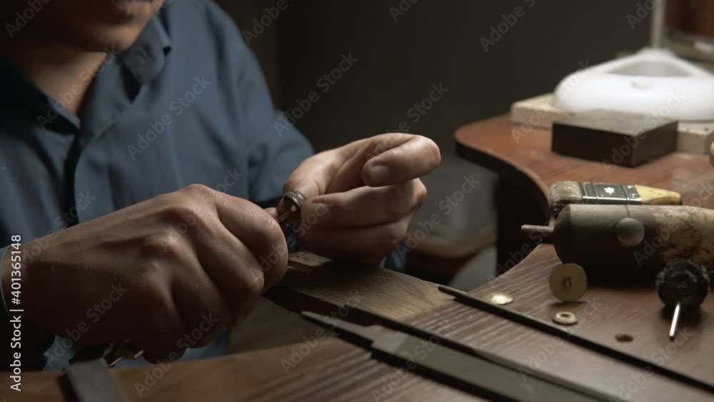 Jeweler uses polishing paste to polish the golden ring. Handcraft, handwork, background Close up of repairing ring by polishing motors tool