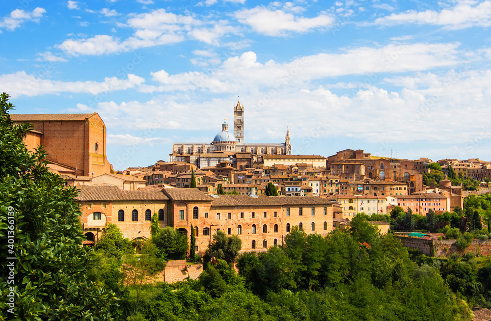 Aerial view over Siena on the dome and bell tower of Siena Cathedral and the old town of the medieval city of Siena on a sunny day, Tuscany, Italy