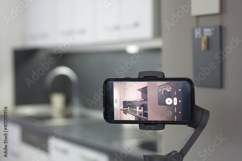Mobile phone recording a home video on a gimbal stabilizer. photo