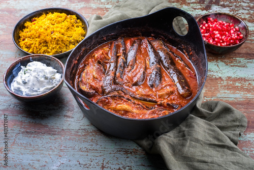 Modern style slow cooked Persian lamb eggplant stew khoresh bademjan served with rice and yoghurt as close-up in a Design pot photo