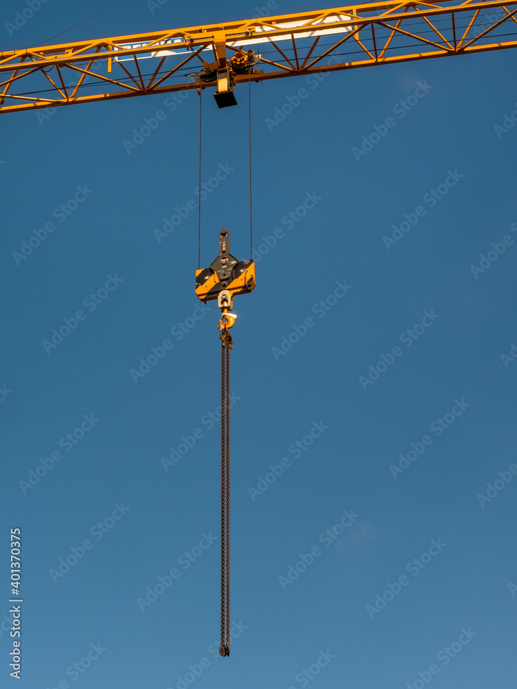 Crane girder with hanging chain on blue sky background Crane girder with hanging chain on blue sky background