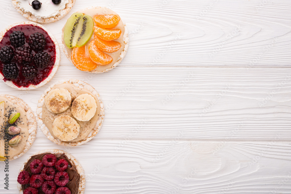 Rice cakes with various topping on a wooden background with copy space