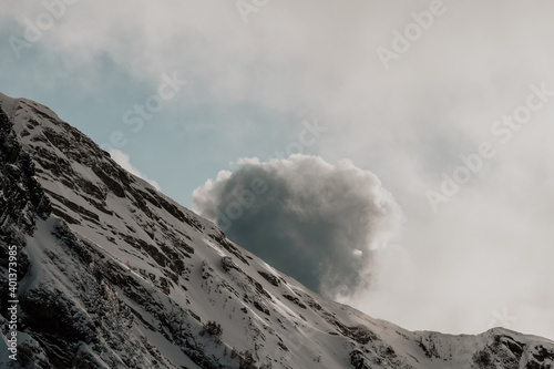 Rosa Khutor. Large cloud over snow-capped mountains.