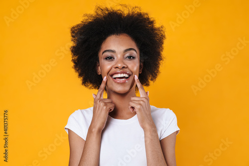 Happy african american girl pointing fingers at her smile