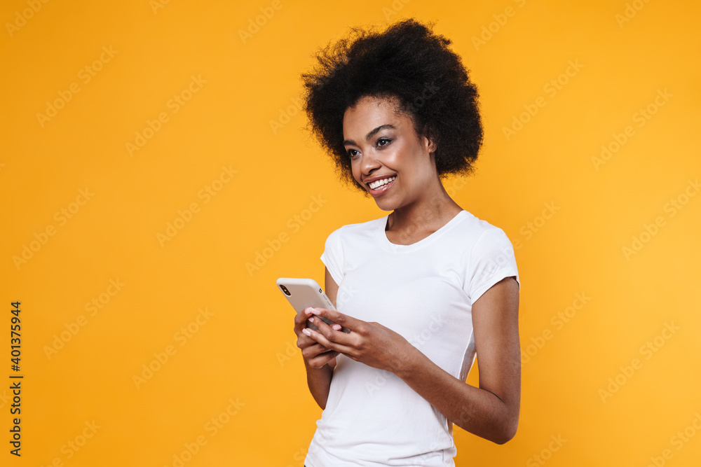 Happy young african american woman smiling and holding cellphone Happy young african american woman smiling and holding cellphone