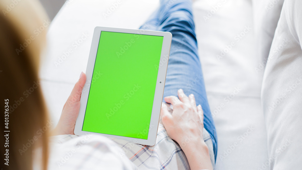 young woman is relaxing on comfortable couch and using tablet at home young woman is relaxing on comfortable couch and using tablet at home