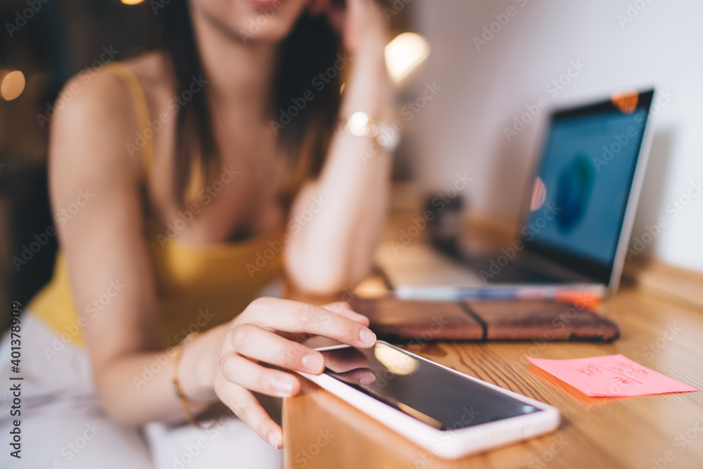 Selective focus on modern smartphone device used by unrecognizable female freelancer checking received text email or app notification, skilled woman browsing website on digital cellular technology Selective focus on modern smartphone device used by unrecognizable female freelancer checking received text email or app notification, skilled woman browsing website on digital cellular technology