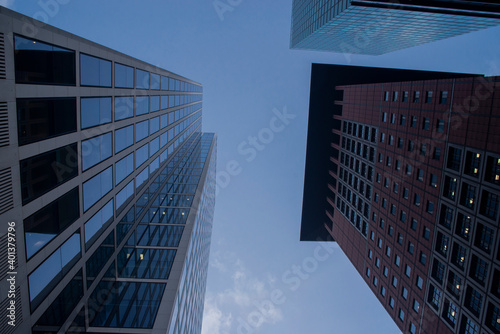 view from the bottom of the house modern business tall glass buildings with windows in the city center with sky