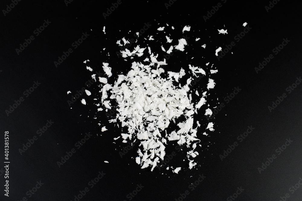 Obraz premium a pile of poured white artificial synthetic snow on a black background