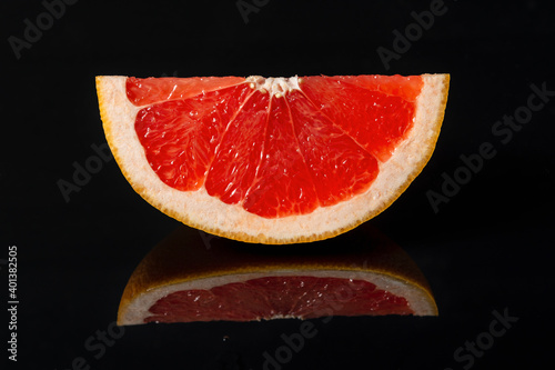 Grapefruit citrus fruit on black background with reflection. Selective focus.