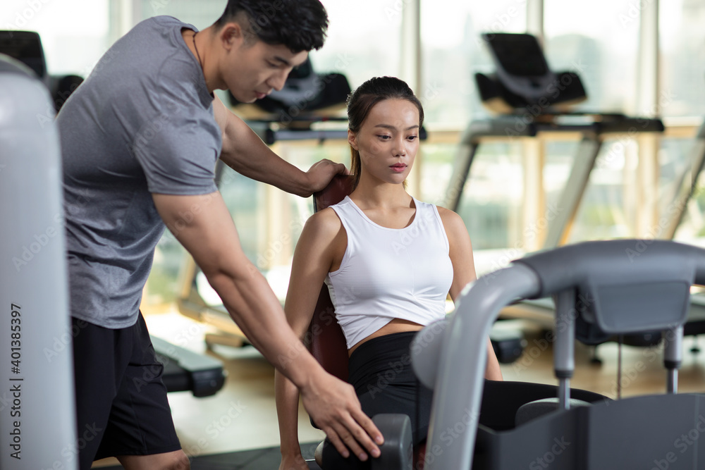 Young woman working out with personal trainer at gym Young woman working out with personal trainer at gym
