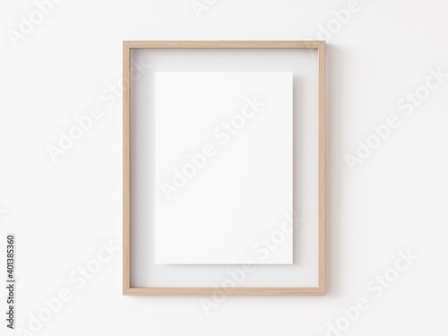 Fototapeta Naklejka Na Ścianę i Meble -  Blank vertically oriented rectangular light wood picture frame hanging on white wall. 3D Illustration.