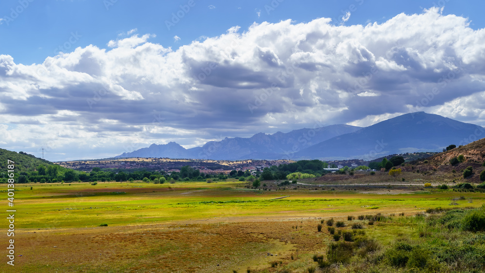 Fototapeta premium Cloudscape on the mountain. Blue sky with clouds and dirt road to the mountain. 