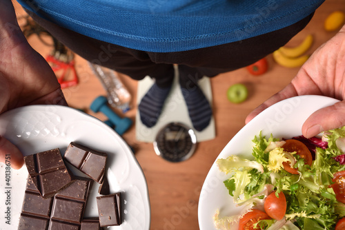 Принти на полотні Person on scale showing plates with healthy and unhealthy food