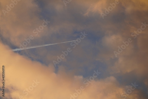 Plane pierces the clouds on a bright morning in Berlin