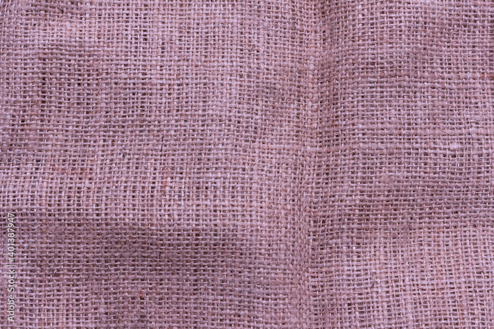 Fototapeta premium The texture of an uneven crumpled, roughly woven burlap.