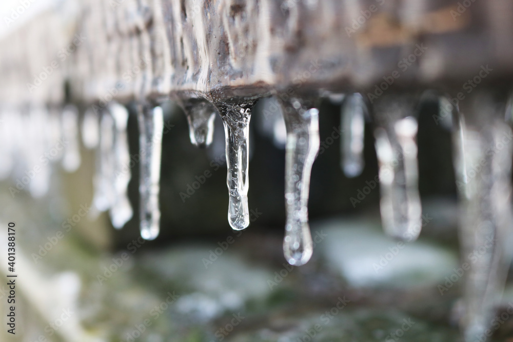 Icicles. The wooden board is frozen over. A rock. Selective focus. Icicles. The wooden board is frozen over. A rock. Selective focus.