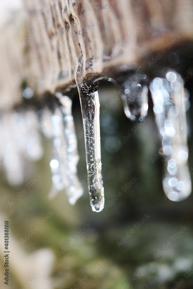 Icicles. The wooden board is frozen over. A rock. Selective focus. Icicles. The wooden board is frozen over. A rock. Selective focus.
