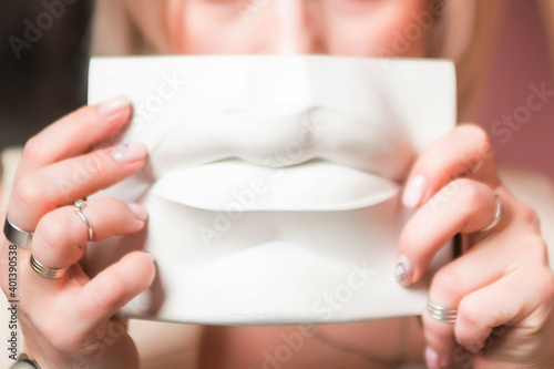 Sculpture of lips in woman hands laike mask  photo