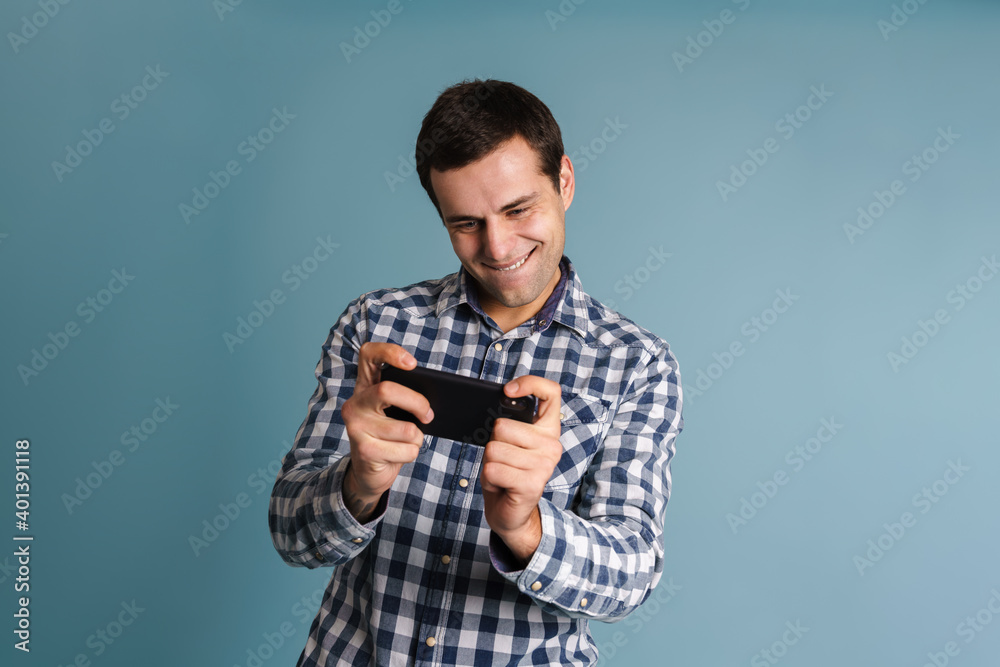 Ezxcited young casual man using smartphone