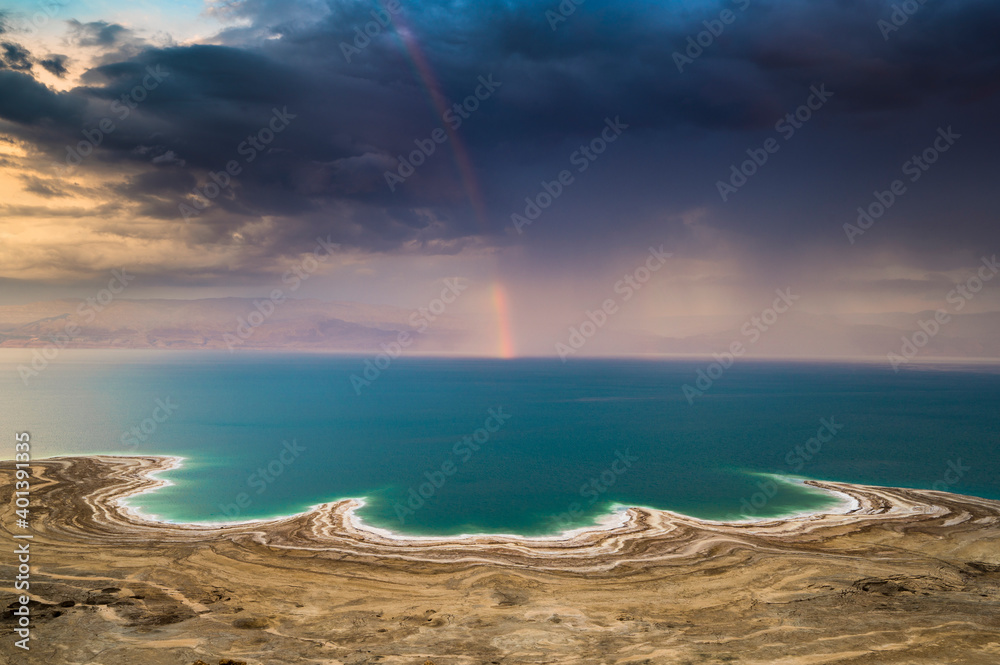 Beautiful Israeli landscape: rainbow in the clouds over the Dead Sea, the lowest place on Earth, its north-western shore covered in sinkholes Beautiful Israeli landscape: rainbow in the clouds over the Dead Sea, the lowest place on Earth, its north-western shore covered in sinkholes