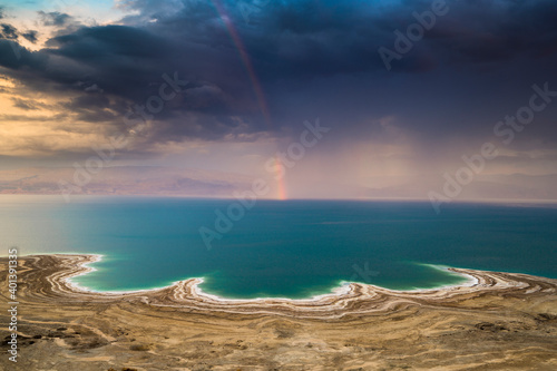 Beautiful Israeli landscape  rainbow in the clouds over the Dead Sea  the lowest place on Earth  its north-western shore covered in sinkholes