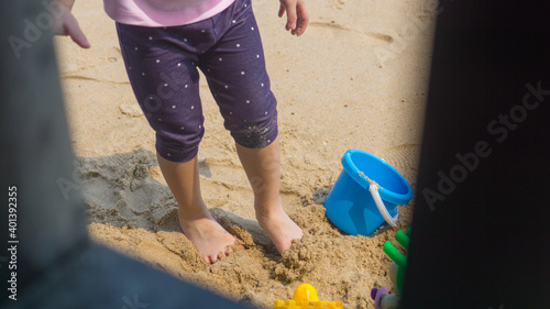 Asian little girl plaing sand on beach outdoor. photo