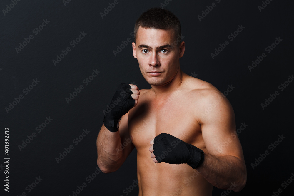 Man bare knuckle fighter stand at black background with boxing bandages
