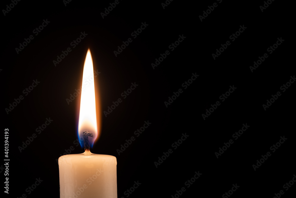 Burning candle in front of a black background with place for text. Burning candle in front of a black background with place for text.
