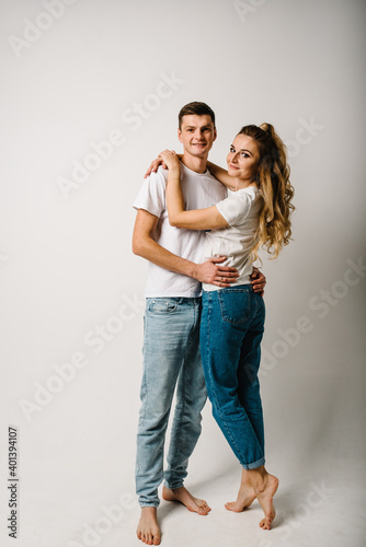 Couple in denim casual style clothes. Fashion models on white background. Smiling young man and woman posing together. Happy family couple.
