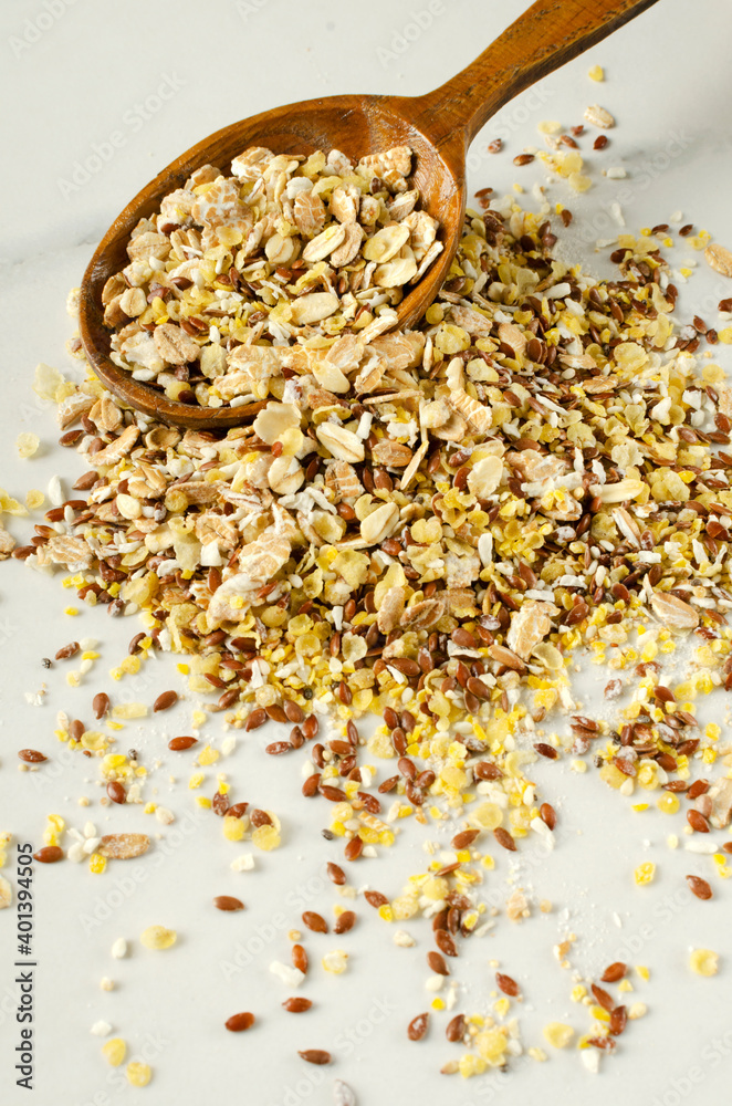 Vertical image of wooden spoon and heap of dry cereal, oat, seeds for healthy eating Vertical image of wooden spoon and heap of dry cereal, oat, seeds for healthy eating