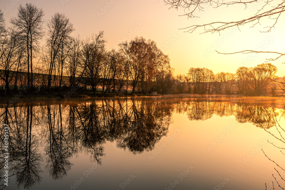 Super beautiful lake, with reflection in the water, nature, trees and a great landscape. Lots of plants and trees great clouds and colors for the sunrise