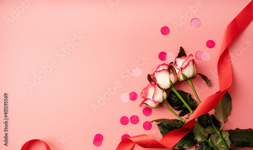 Pink roses with confetti on solid pink background