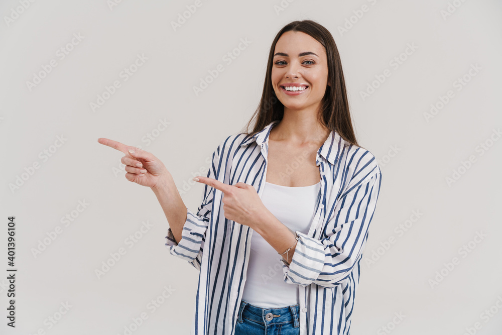 Happy beautiful brunette girl smiling and pointing finger aside Happy beautiful brunette girl smiling and pointing finger aside
