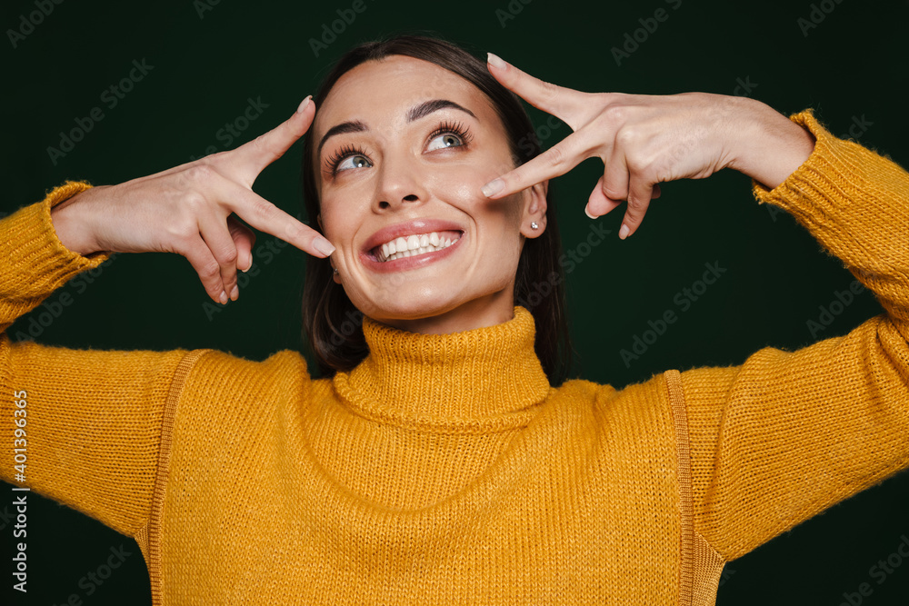 Joyful beautiful girl smiling and showing peace gesture Joyful beautiful girl smiling and showing peace gesture