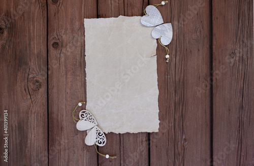 Blank or blank paper with wooden hearts on a wooden background. Space for text, cpy space. The concept of Valentine's Day. photo