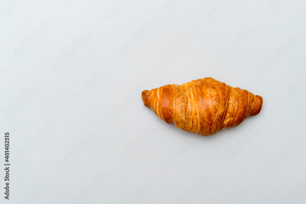 Fresh tasty croissant on grey background. French pastry