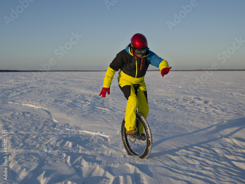 Unicyclist rides in the snowy desert © Sergei