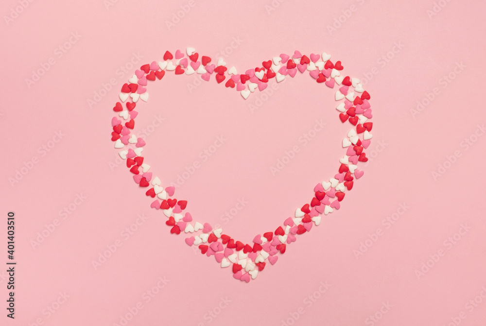 Heart made of sweet colorful confetti on pastel pink background. Valentines day, celebration or mothers day minimal composition. Top view, frame, flat lay, copy space Heart made of sweet colorful confetti on pastel pink background. Valentines day, celebration or mothers day minimal composition. Top view, frame, flat lay, copy space