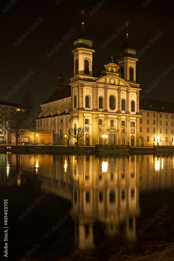 Nächtlich beleuchtete Jesuitenkirche an der Reuss, Luzern, Schweiz